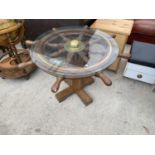 A SHIP'S WHEEL COFFEE TABLE WITH GLASS TOP