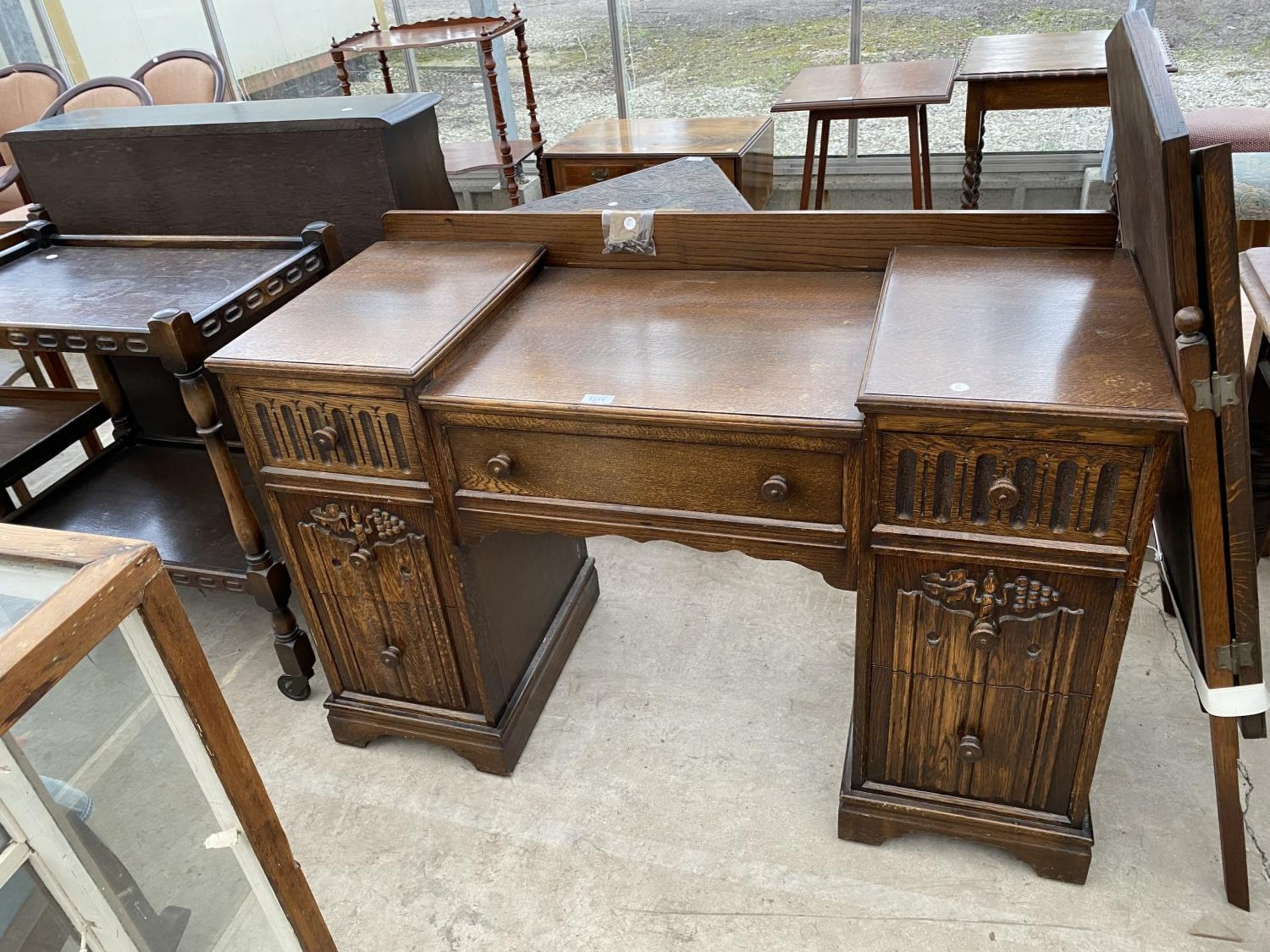 A PRIORY STYLE OAK DRESSING TABLE WITH ONE LONG AND SIX SHORT DRAWERS AND THREE SECTION MIRROR