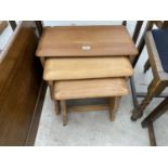 A POSSIBLY ERCOL LIGHT OAK NEST OF THREE TABLES