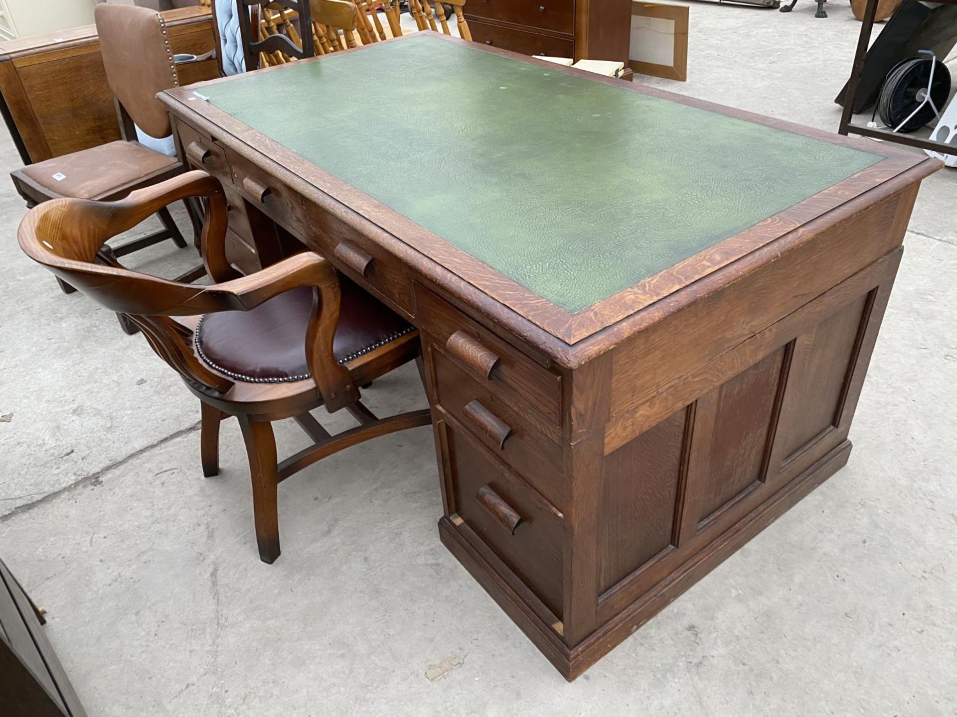 AN OAK PARTNER'S DESK WITH SEVEN DRAWERS AND GREEN LEATHER WRITING SURFACE AND A MAHOGANY CAPTAIN'