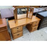 A PINE DRESSING TABLE WITH SIX DRAWERS AND A PINE THREE SECTION MIRROR