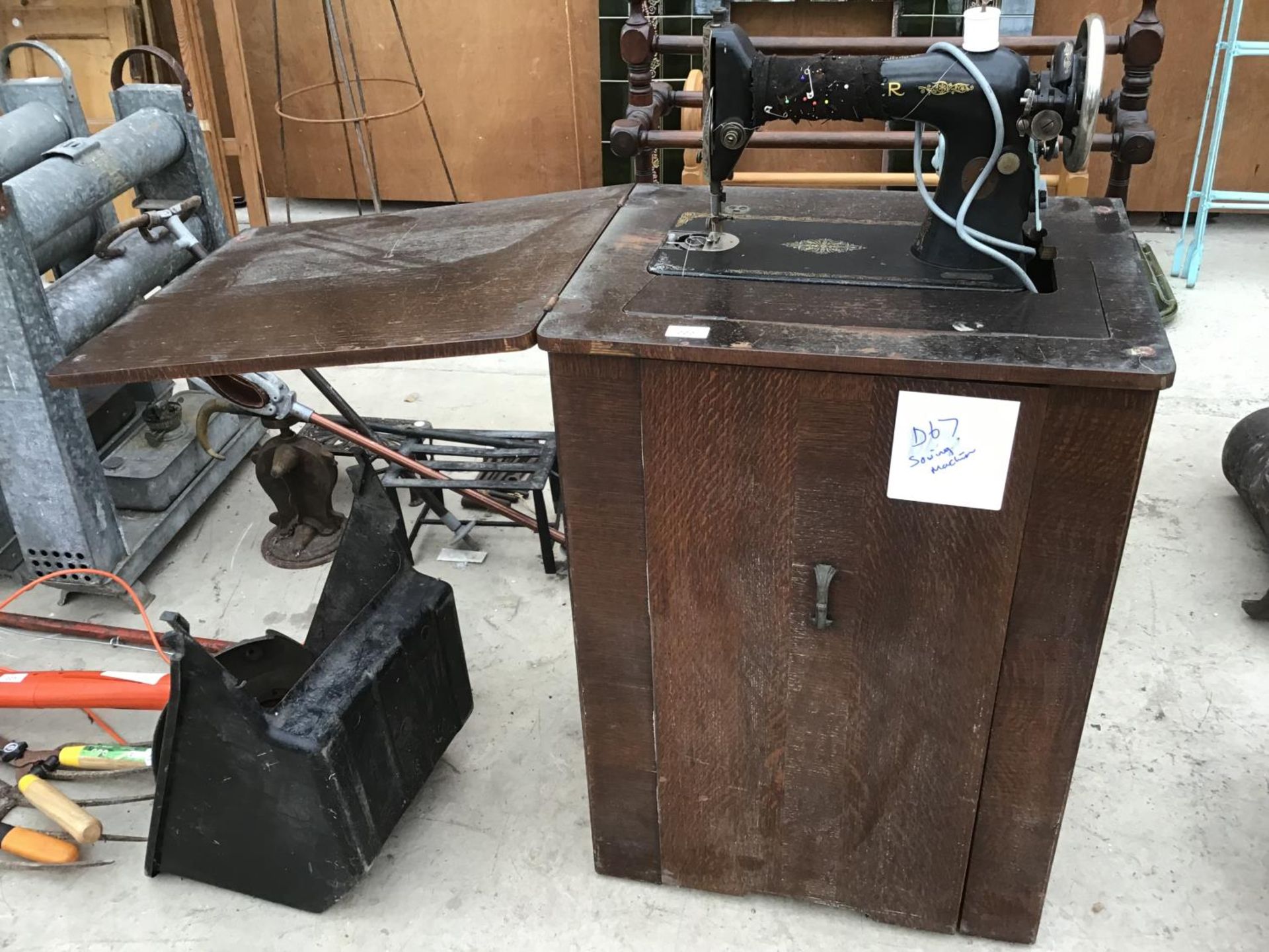 AN ELECTRIC SINGER SEWING MACHINE IN A WOODEN CABINET WITH INNER STORAGE BOX IN WORKING ORDER