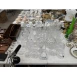 A LARGE COLLECTION OF ASSORTED CRYSTAL CUT GLASSWARE TO INCLUDE VASES, DECANTERS, BOWLS ETC