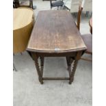 AN OVAL OAK DROP LEAF DINING TABLE ON BARLEY TWIST SUPPORTS