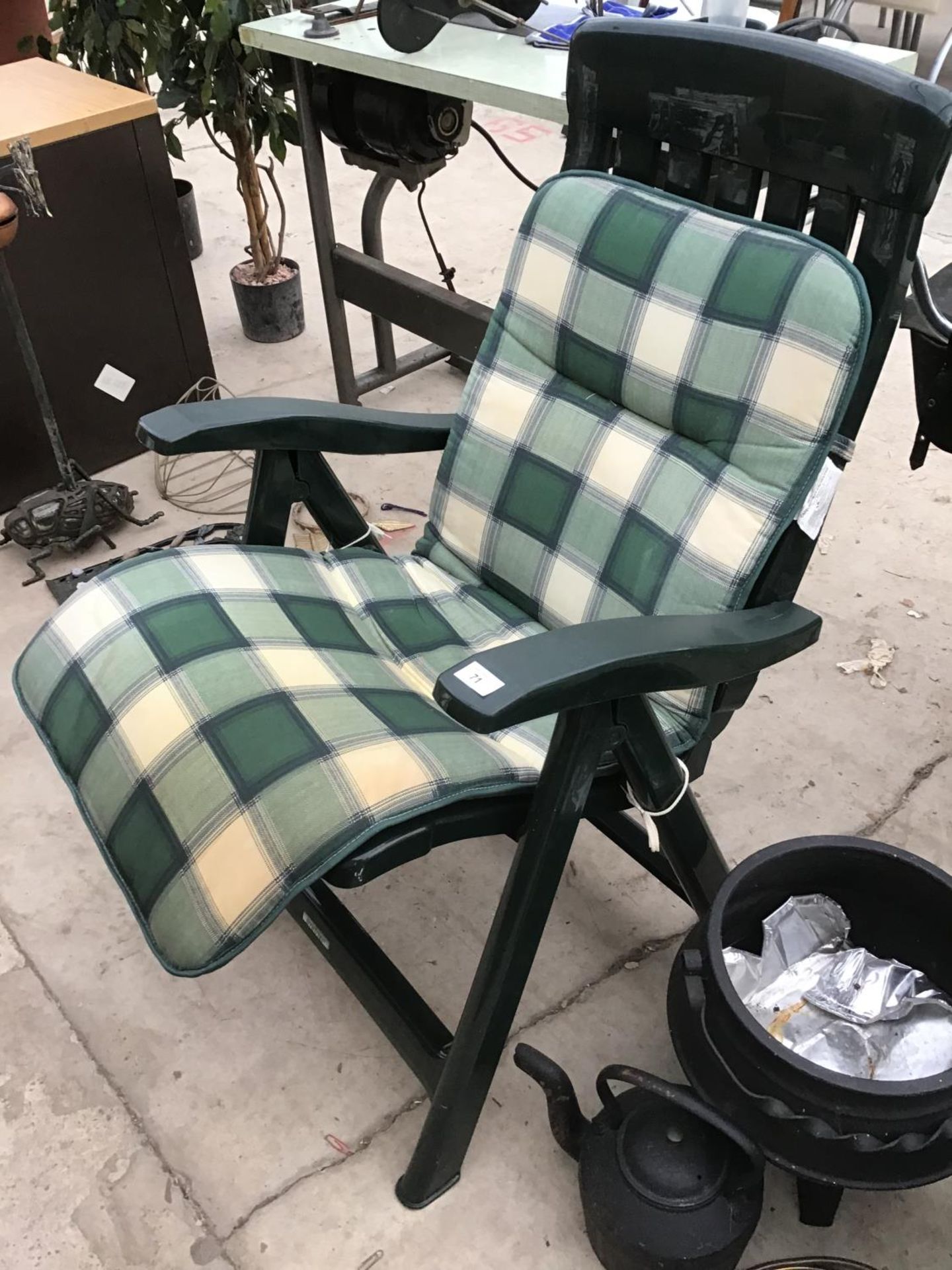 A GREEN PLASTIC GARDEN CHAIR WITH A CHECKED SEAT PAD