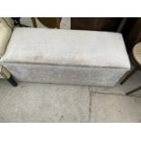 AN UPHOLSTERED OTTOMAN