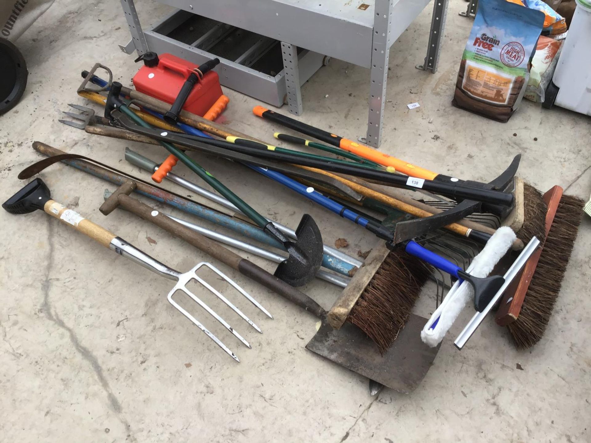 A LARGE COLLECTION OF TOOLS TO INCLUDE FORK, BRUSHES, SHOVEL,RAKE, PICK AXE, PETROL CAN ETC