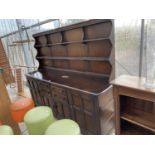 A LARGE ERCOL ELM DRESSER WITH FOUR DOORS, FOUR DRAWERS AND UPPER PLATE RACK