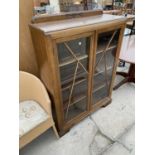 AN ART DECO STYLE OAK CABINET WITH TWO GLAZED PANEL DOORS