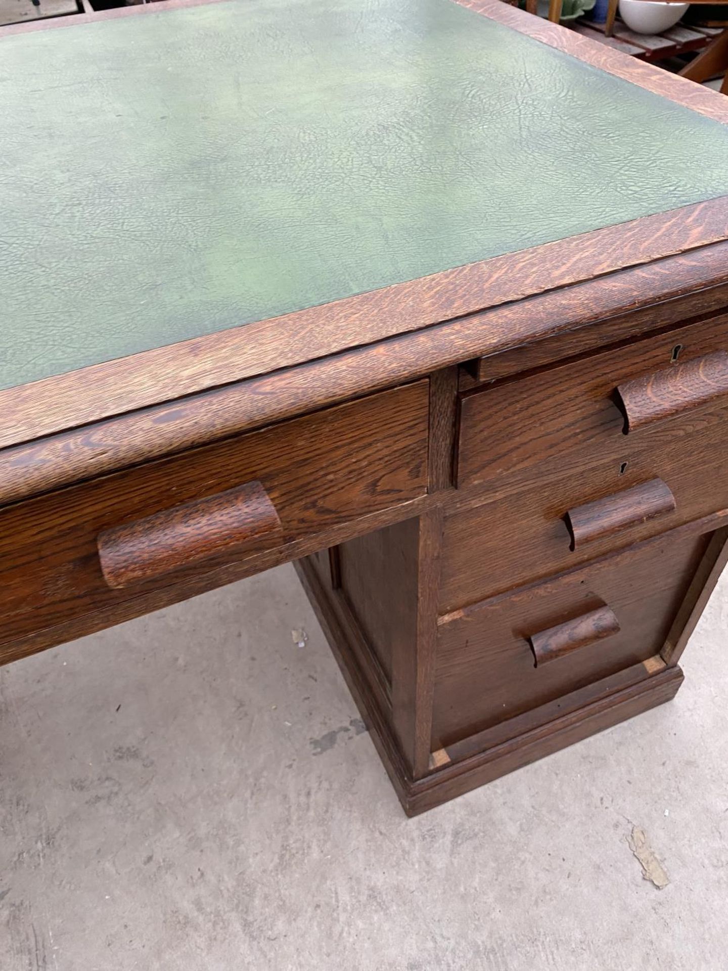 AN OAK PARTNER'S DESK WITH SEVEN DRAWERS AND GREEN LEATHER WRITING SURFACE AND A MAHOGANY CAPTAIN' - Image 4 of 8
