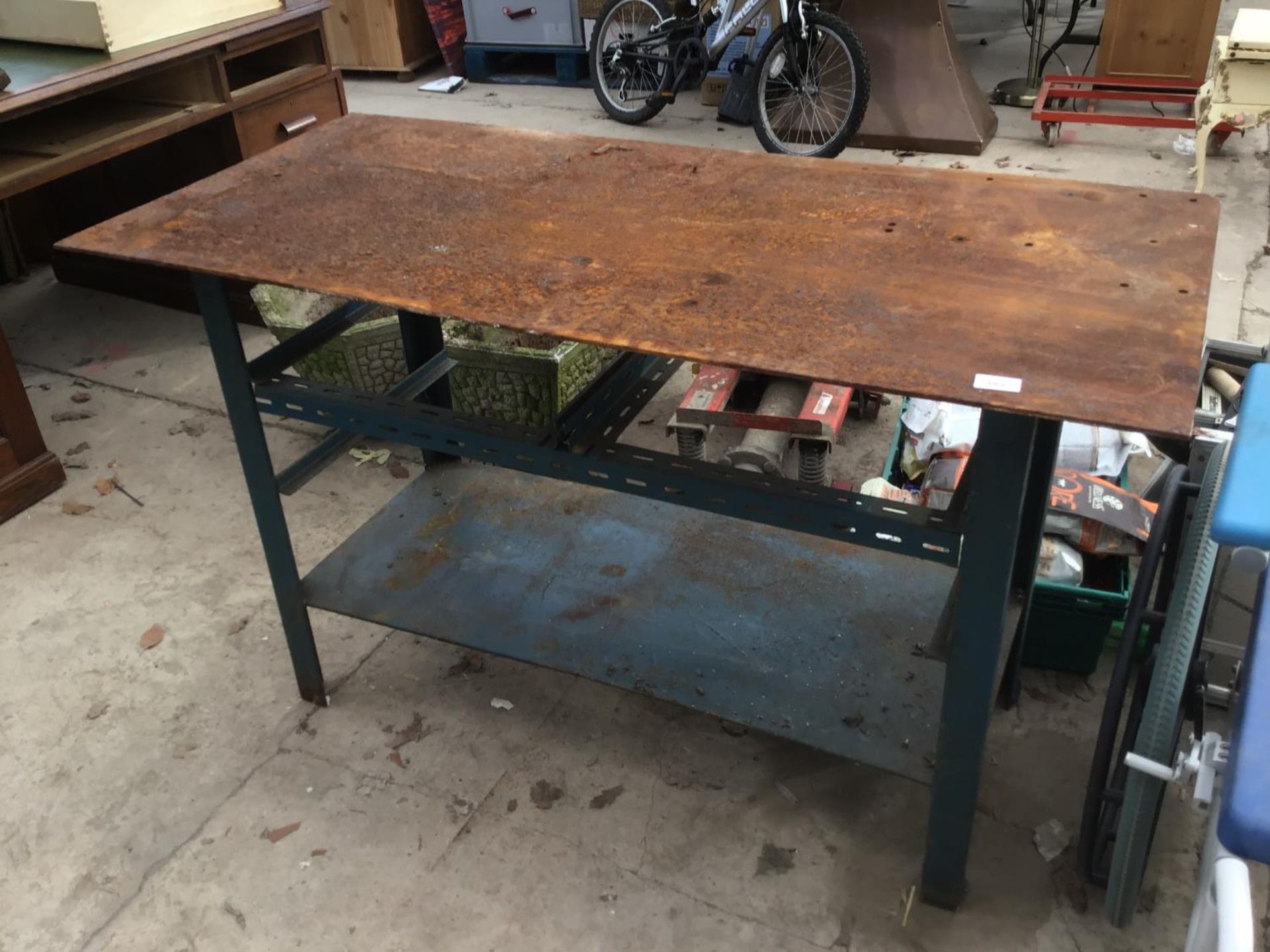 A METAL WORK BENCH WITH LOWER SHELF