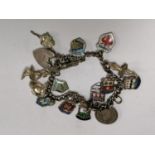 A LADIES SILVER CHARM BRACELET WITH SIXTEEN CHARMS