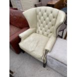A STUDDED CREAM LEATHER WING AND BUTTON BACK ARMCHAIR