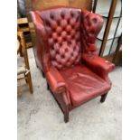 AN OX BLOOD LEATHER BUTTON AND WING BACK CHESTERFIELD ARMCHAIR