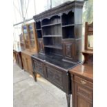 A CARVED OAK DRESSER ON CABRIOLE SUPPORTS WITH TWO LOWER DOORS AND UPPER PLATE RACK WITH TWO DOORS