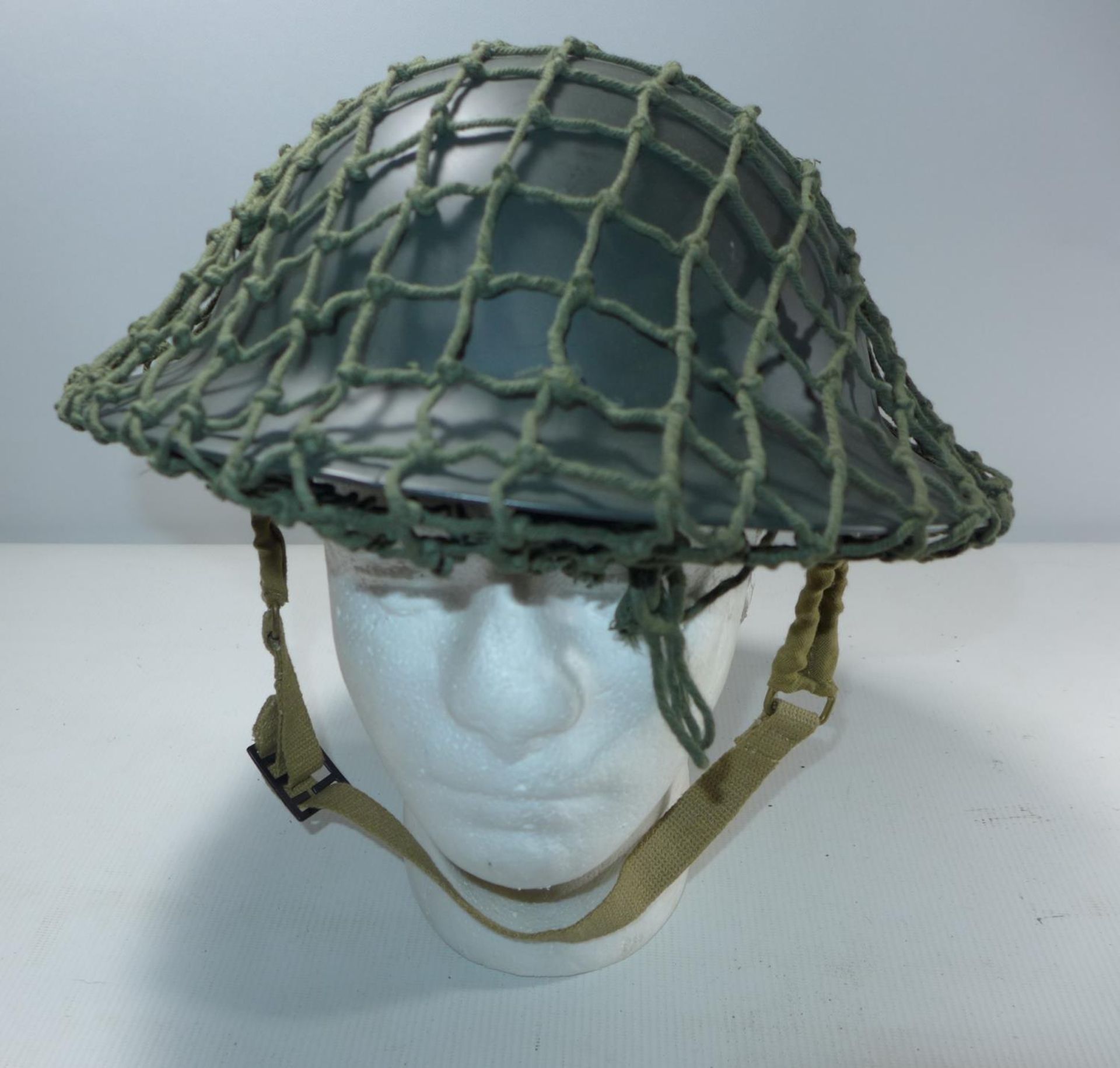 A BRITISH TOMMY HELMET AND NET COVER