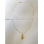 A 9 CARAT GOLD TEDDY BEAR PENDANT AND NECKLACE CHAIN. WEIGHT 2.2 GRAMS, CHAIN 42 CM