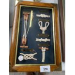 A WOODEN FRAMED GLASS FRONTED KEY STORAGE BOX DEPICTING VARIOUS SAILING KNOTS