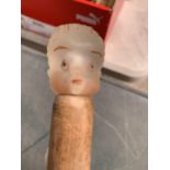 A WOODEN WALKING STICK WITH A GLASS HEAD OF A CHILD