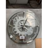 AN UNUSUAL SILVER COLOURED CLOCK SHOWING COG WORKINGS 30 CM DIAMETER