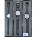THREE NEW AND BOXED FASHION WATCHES WITH BLACK CANVAS STRAPS - ENGRAVED ON THE BACK - EAGLEMOSS