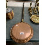 A BRASS WARMING PAN WITH WOODEN HANDLE