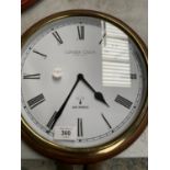 A WOODEN AND BRASS FRAMED LONDON CLOCK COMPANY RADIO CONTROLLED CLOCK WITH WHITE FACE AND BLACK