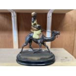 A LARGE BRONZE MODEL OF A CAMEL AND RIDER ON MARBLE BASE