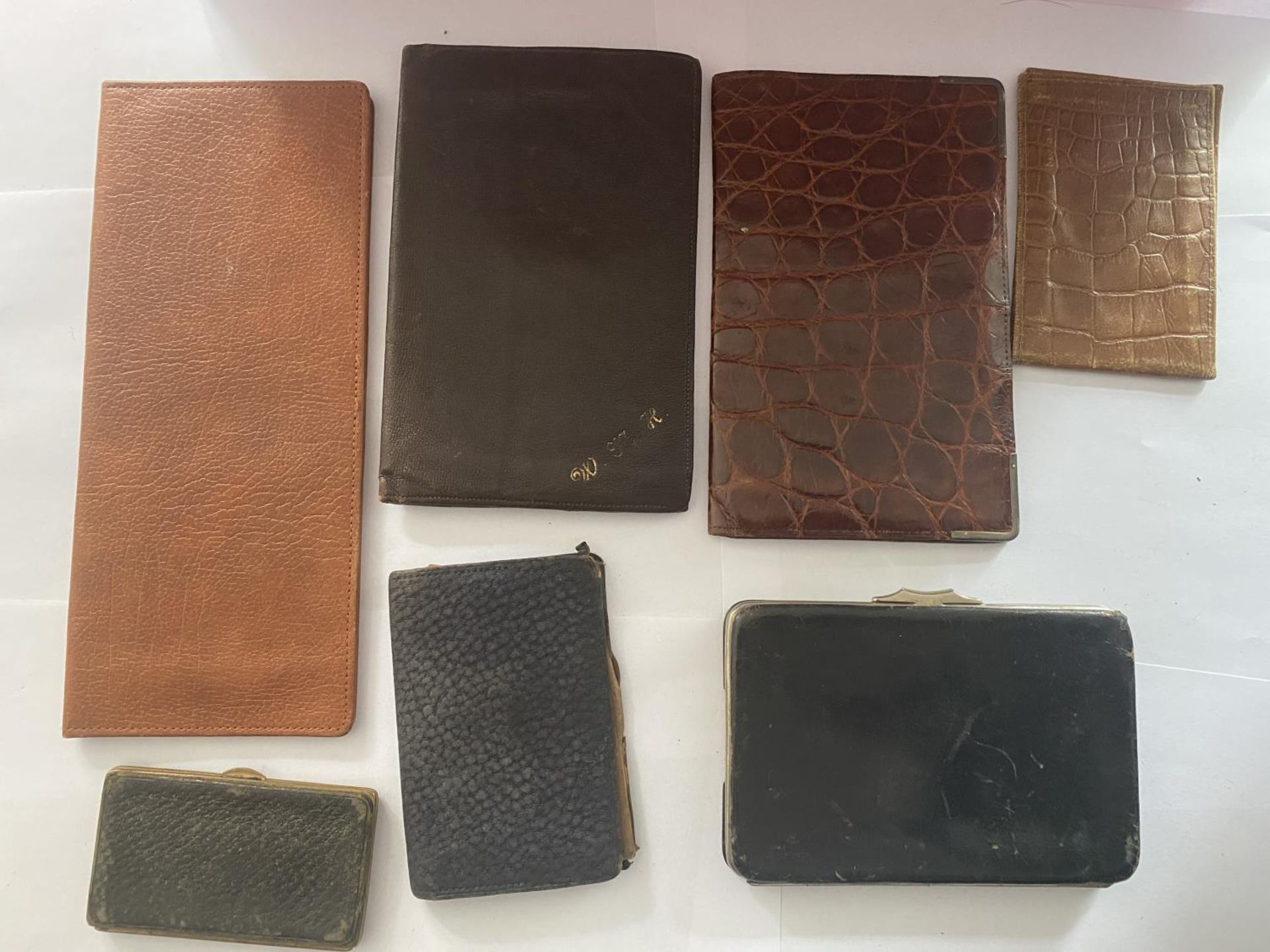SEVEN VINTAGE WALLETS AND PURSES INCLUDING ONE WITH HALLMARKED BIRMINGHAM SILVER CORNERS
