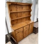 A PINE DRESSER WITH THREE DOORS, THREE DRAWERS AND UPPER PLATE RACK