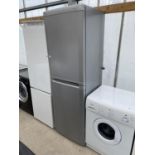 A SILVER UPRIGHT FRIDGE FREEZER IN NEED OF MINOR CLEAN