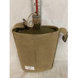 A CANVAS COVERED ARMY DRINKING BOTTLE WITH CORK STOPPER