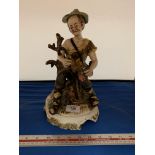 AN ITALIAN FIGURE OF A MAN SAT ON A LOG 30CM TALL