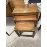 A MAHOGANY NEST OF TABLES WITH BRASS CORNERS AND DECORATION