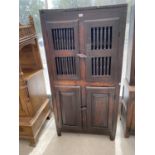 AN 18TH CENTURY OAK LARDER CUPBOARD WITH TWO LOWER DOORS AND TWO UPPER DOORS WITH TURNED STRUT