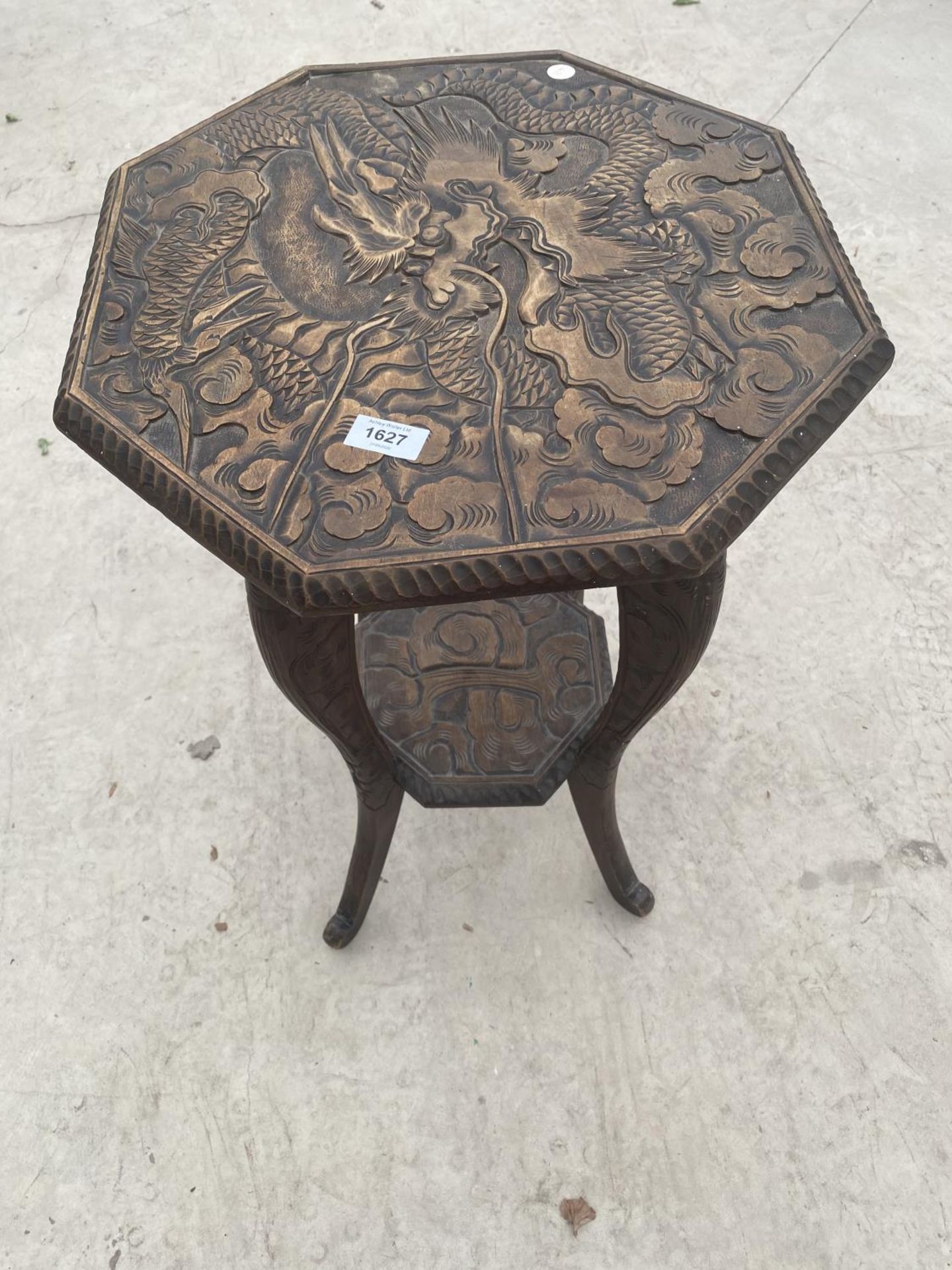 AN OCTAGONAL MAHOGANY SIDE TABLE WITH HEAVILY CARVED TOP, LOWER SHELF AND SUPPORTS