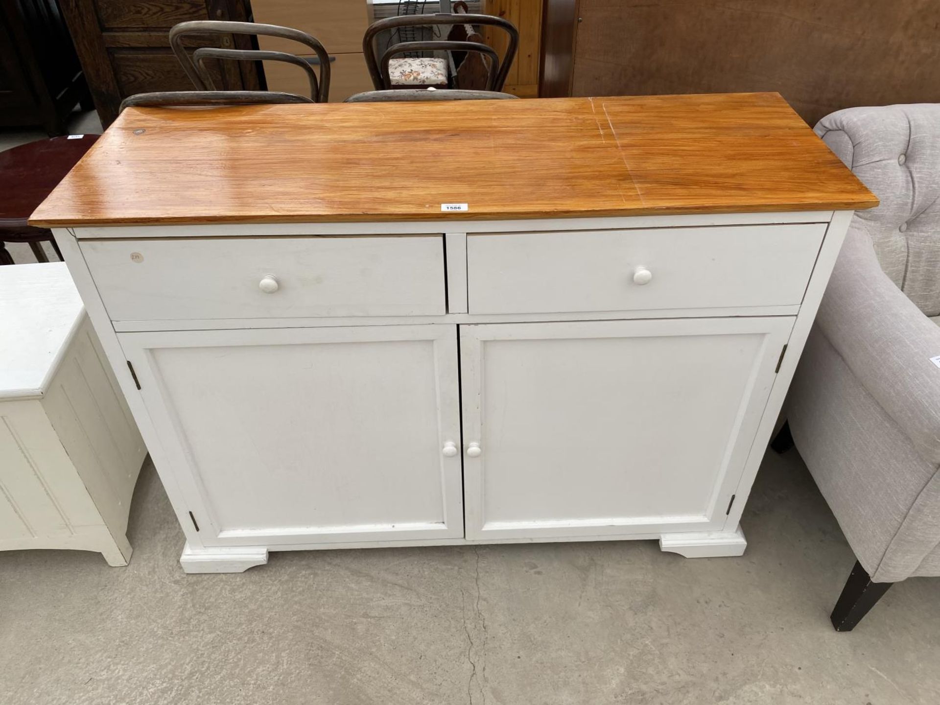 A WHITE CABINET WITH TWO DOORS, TWO DRAWERS AND PINE TOP