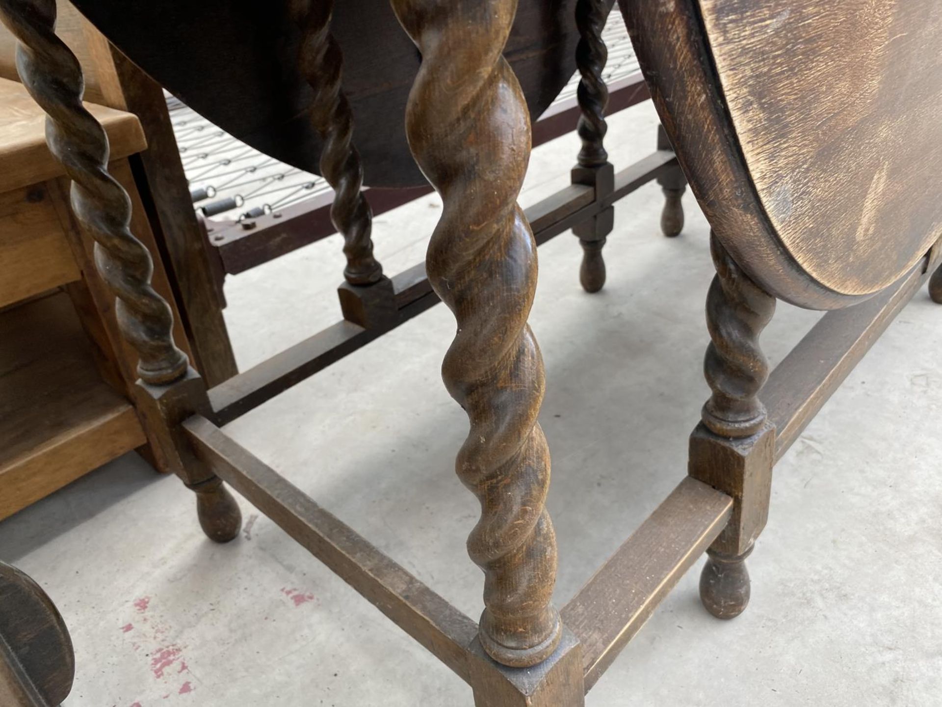 AN OVAL OAK DROP LEAF DINING TABLE ON BARLEY TWIST SUPPORTS - Image 4 of 4