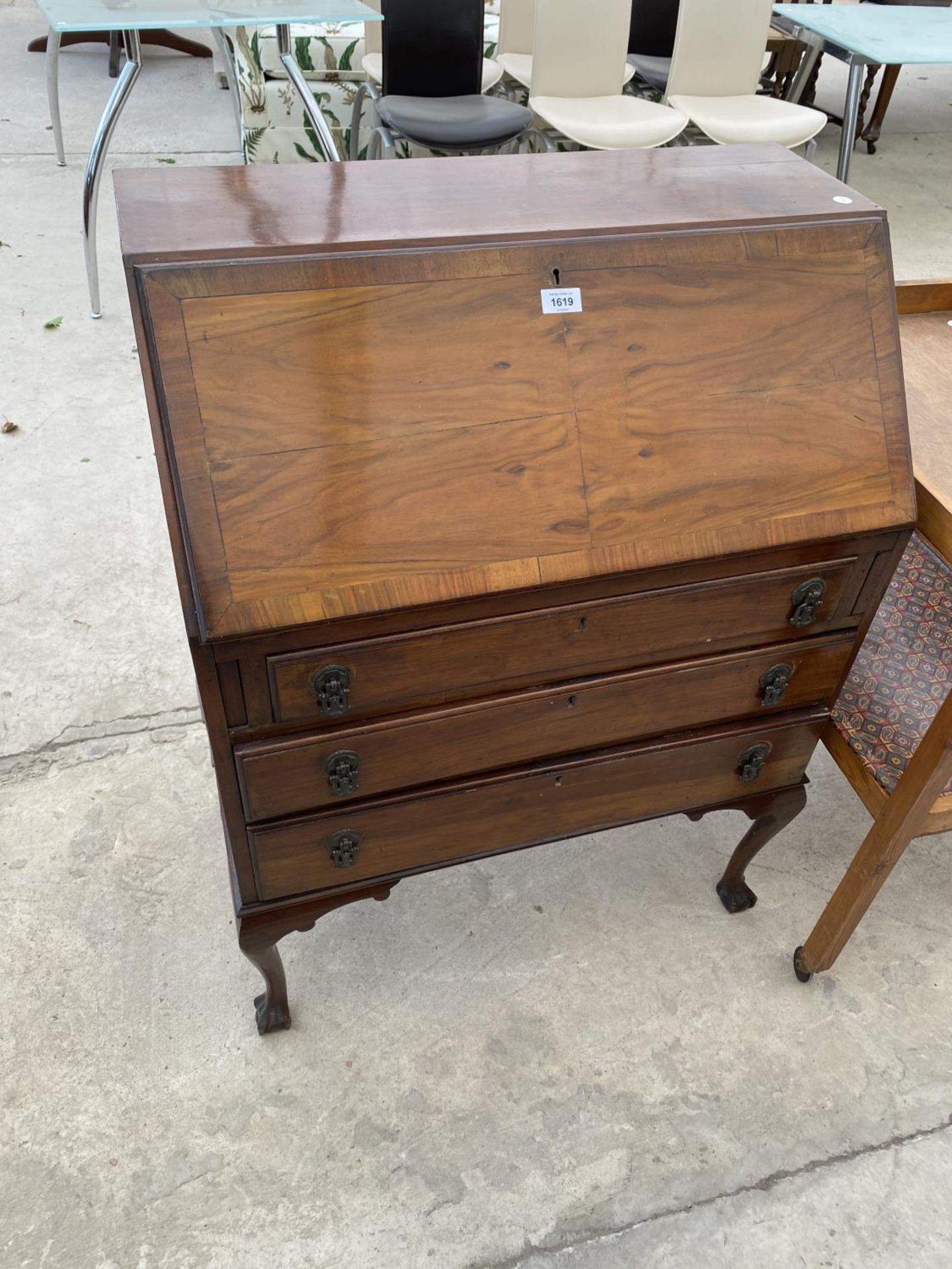 A MAHOGANY BUREAU ON CABRIOLE SUPPORTS WITH FALL FRONT AND THREE DRAWERS