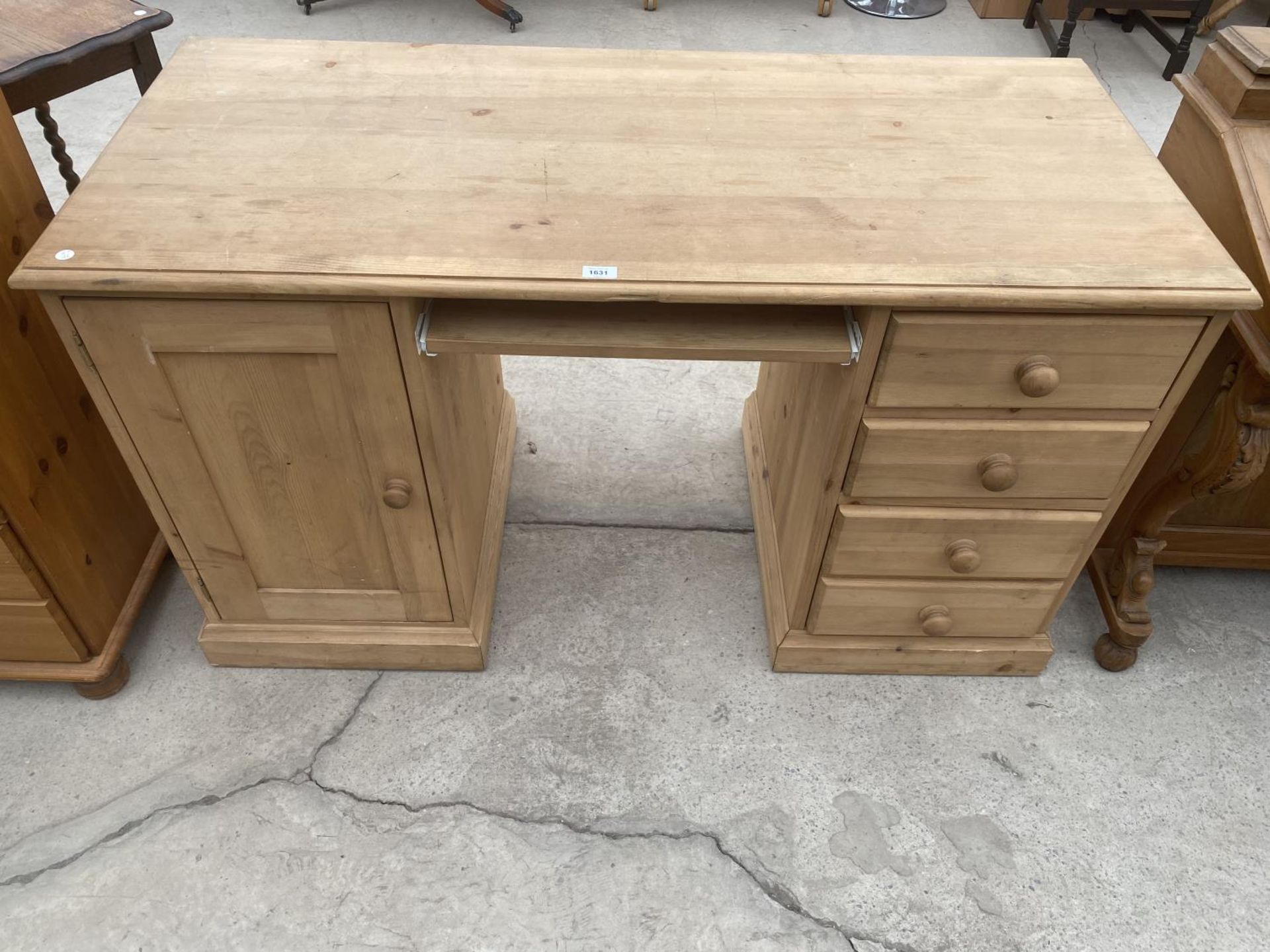 A PINE DESK WITH ONE DOOR AND FOUR DRAWERS