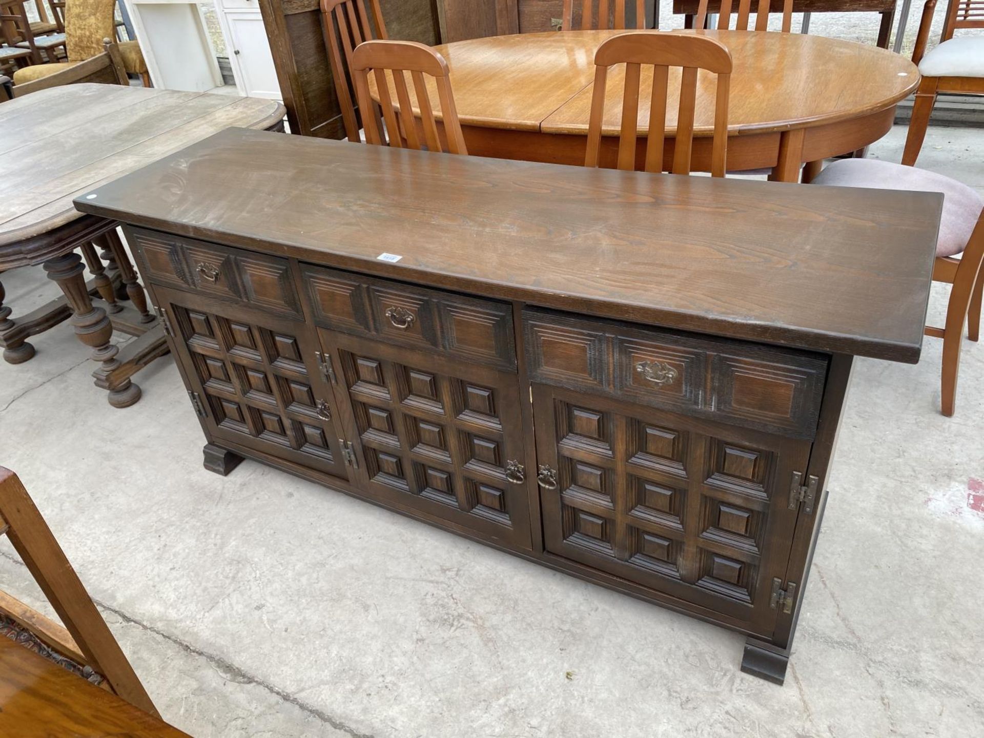 A YOUNGER TOLEDO OAK SIDEBOARD WITH THREE DOORS AND THREE DRAWERS