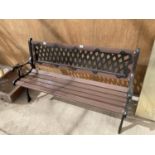 A WOODEN BENCH WITH CAST IRON ENDS AND LATTICE WORK BACK