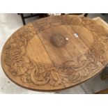 AN OVAL OAK SIDE TABLE WITH CARVED TOP