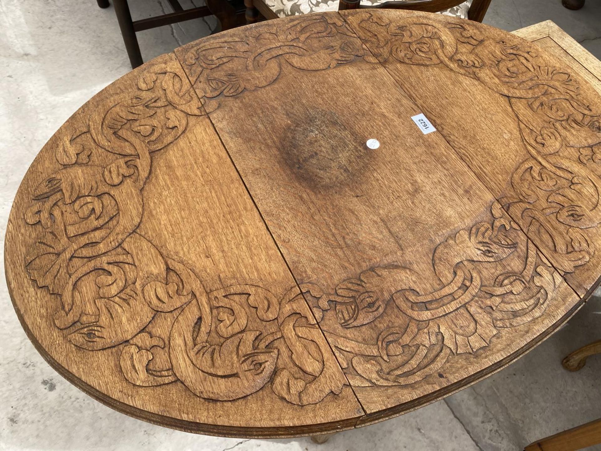 AN OVAL OAK SIDE TABLE WITH CARVED TOP
