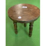 A SMALL OAK STOOL WITH THREE LEGS