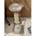 A SUNDIAL ON A CONCRETE BASE AND A CONCRETE BIRD BATH