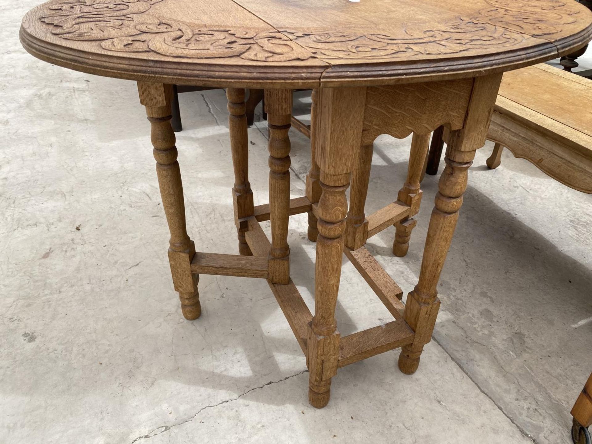 AN OVAL OAK SIDE TABLE WITH CARVED TOP - Image 2 of 2