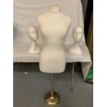 A MANNEQUIN ON A BRASS CLOUTED STAND AND A PAIR OF POLYSYTRENE HEADS