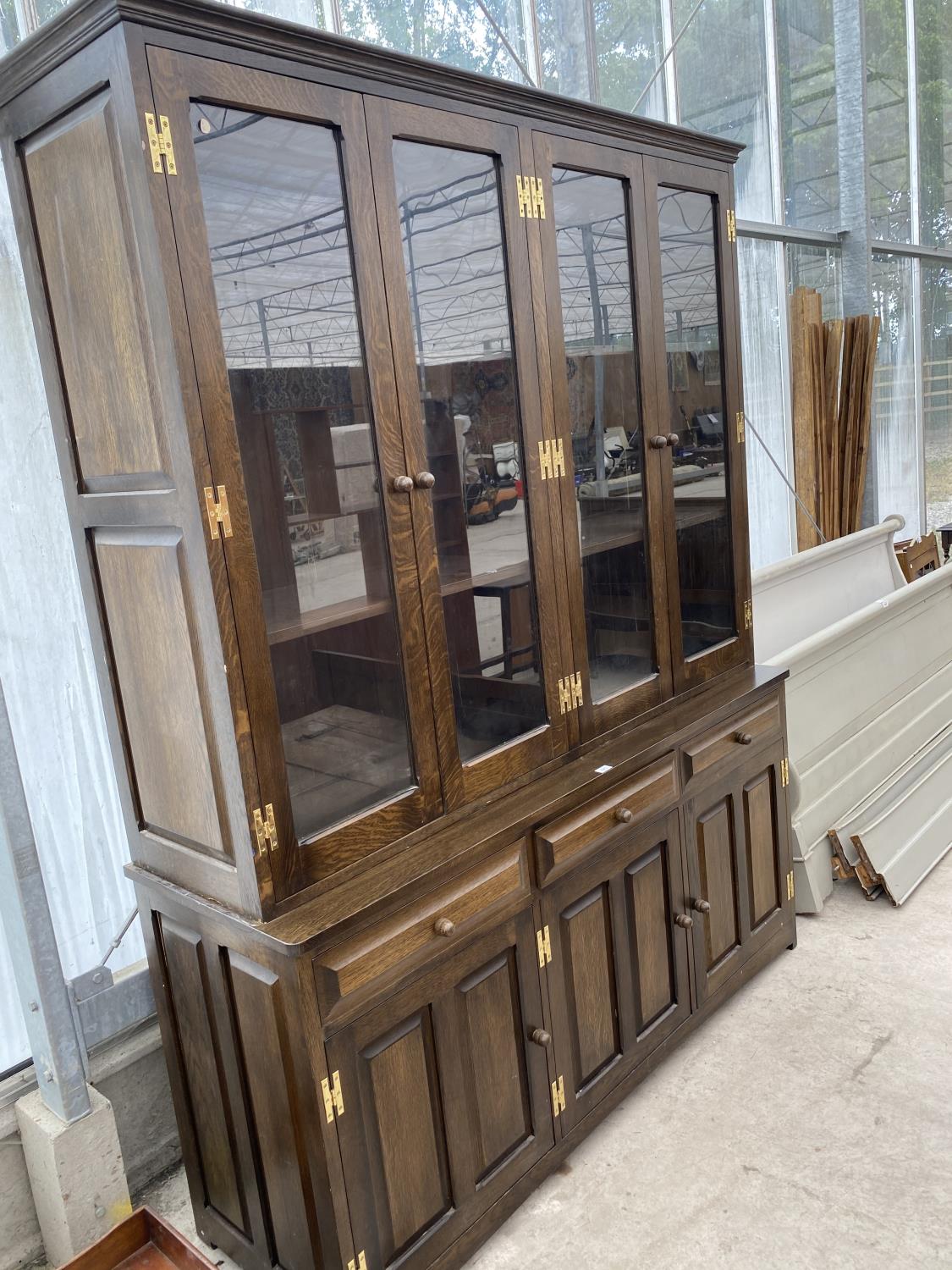 A LARGE SOLID OAK CABINET WITH THREE LOWER DOORS AND DRAWERS AND FOUR UPPER GLAZED DOORS