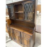 A PRIORY STYLE OAK DRESSER WITH THREE DOORS, THREE SRAWERS AND TWO UPPER LEAD GLAZED DOORS